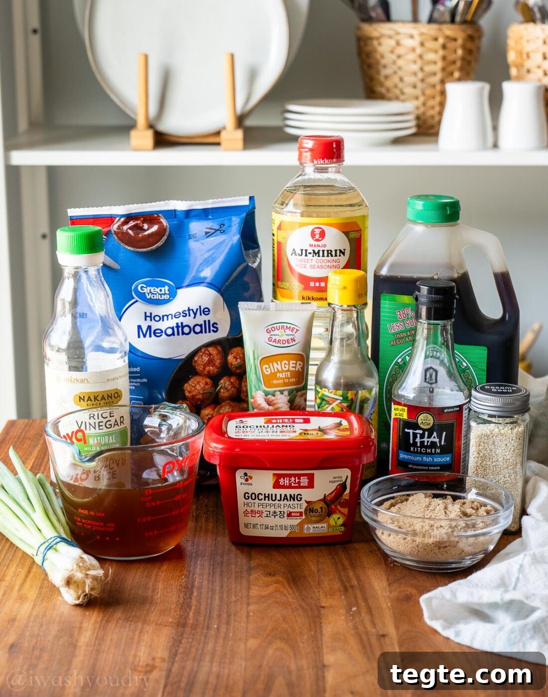 ingredients for korean bbq meatballs with sauce on a wooden surface.