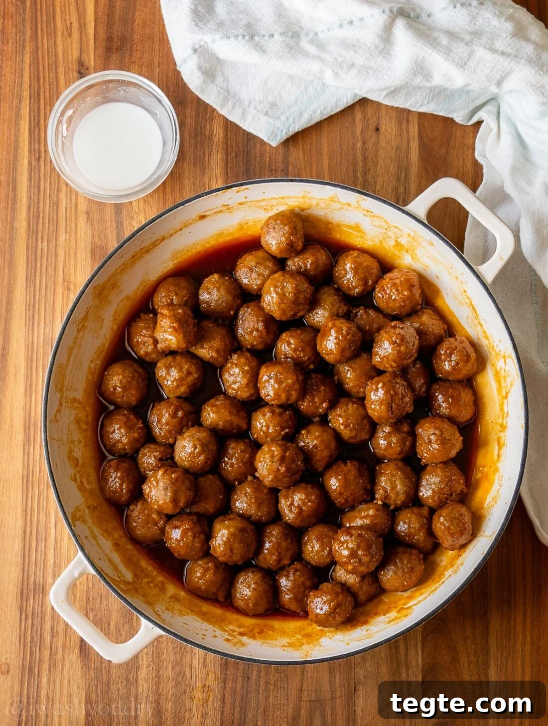 meatballs in sauce with cornstarch slurry next to it.
