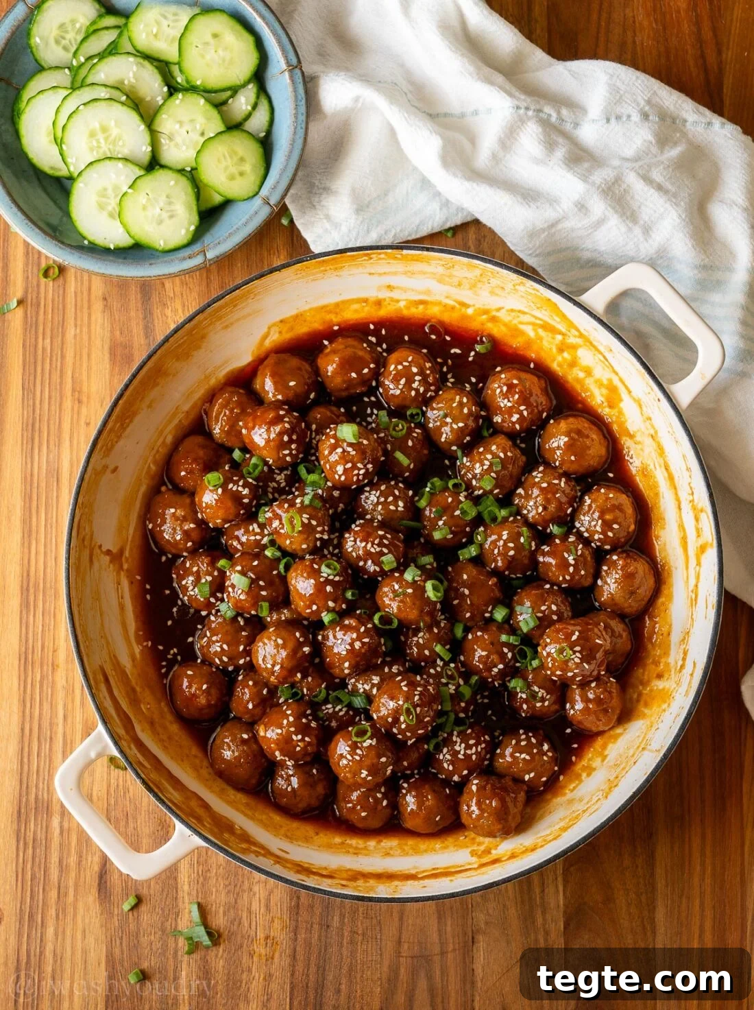 pan with meatballs and bowl of cucumbers near by