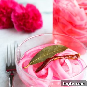 Bowl of Mexican pickled onions with a jar of pickled onions behind it
