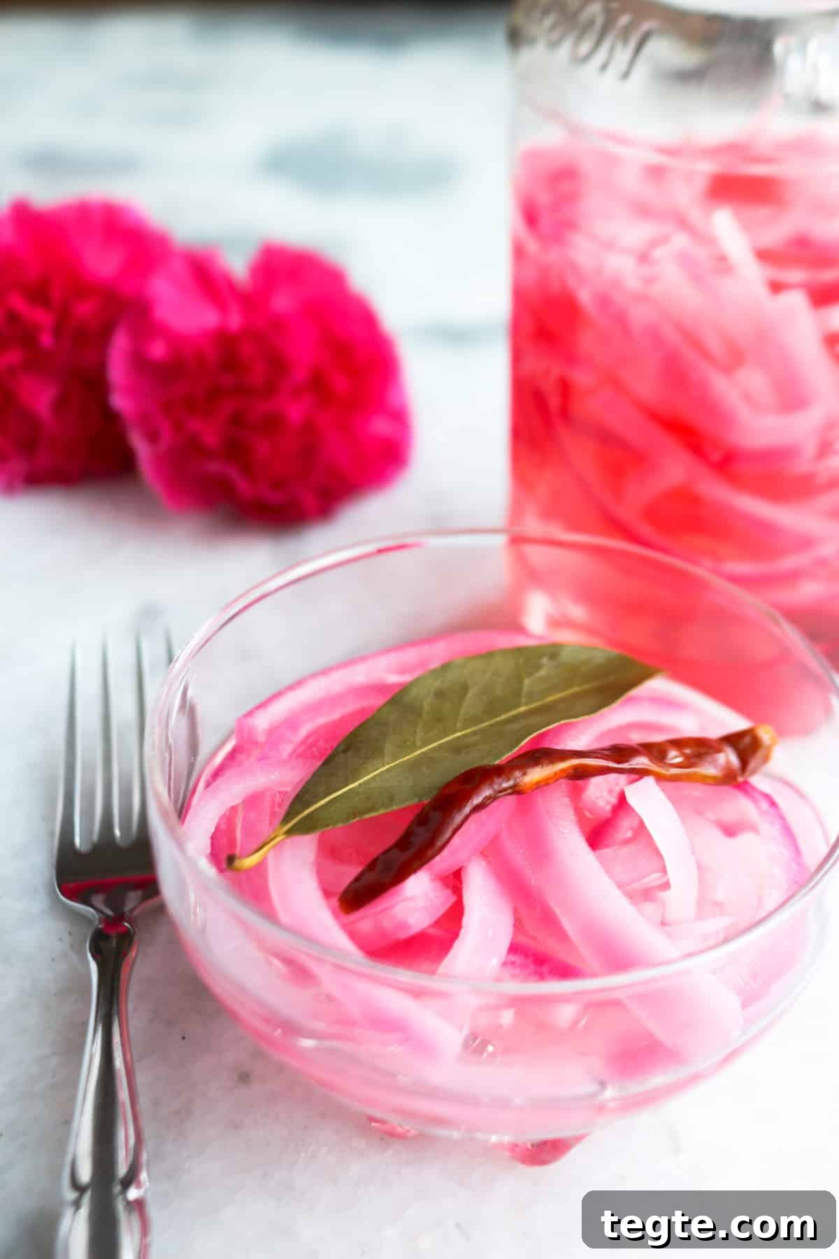 Bowl of Mexican pickled onions with a jar of pickled onions behind it