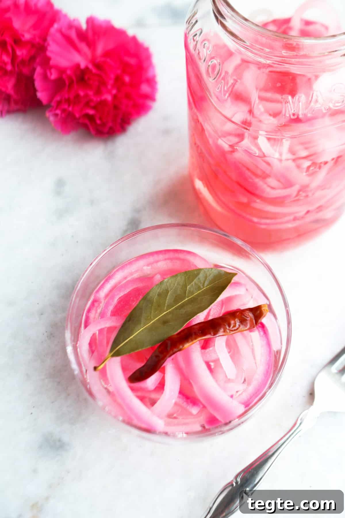 Bowl of Mexican pickled onions with a jar of pickled onions behind it