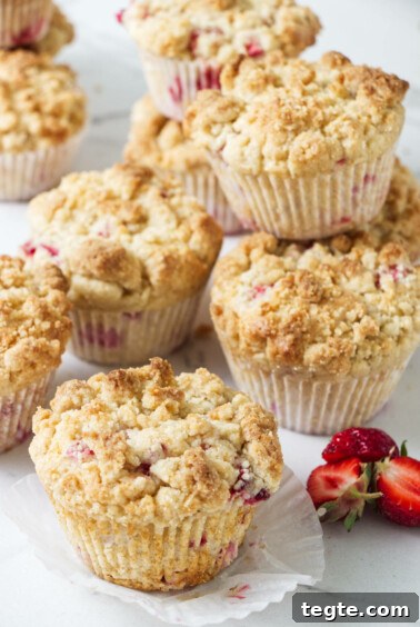 Several baked strawberry rhubarb muffins.