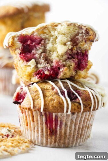 Two strawberry white chocolate muffins stacked on top of each other.
