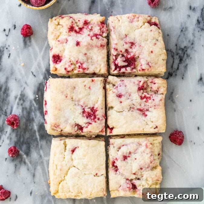Overhead shot of six raspberry scones on gray marble