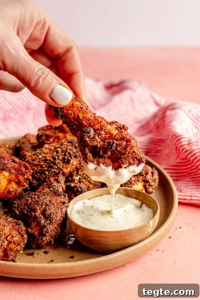 Crispy Dry Rub Chicken Wings Recipe for Perfect Flavor 5 Hand holding a dry rub chicken wing dipped in ranch dressing.