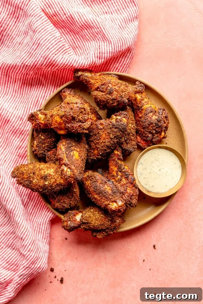 Crispy Dry Rub Chicken Wings Recipe for Perfect Flavor 6 Brown plate with dry rubbed chicken wings served next to a side of ranch dressing.