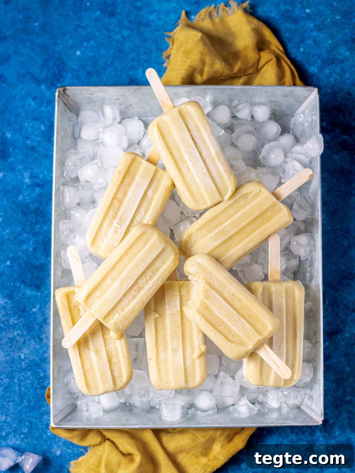 Creamy Homemade Banana Popsicles Recipe for Cooling Summer Treats 2 banana popsicles on a tray with ice