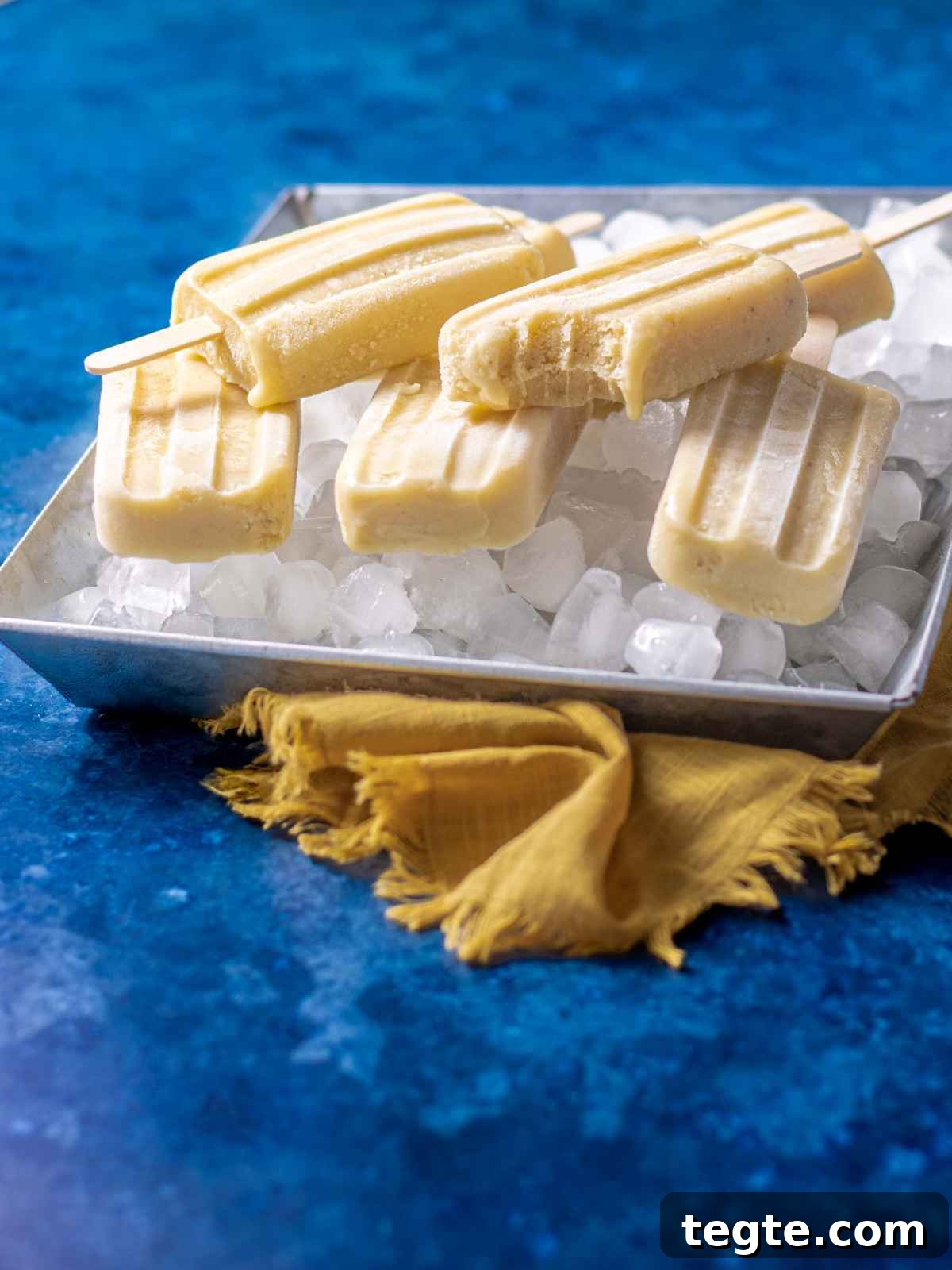Creamy Homemade Banana Popsicles Recipe for Cooling Summer Treats 6 A bite of banana pudding mix popsicle on a tray.