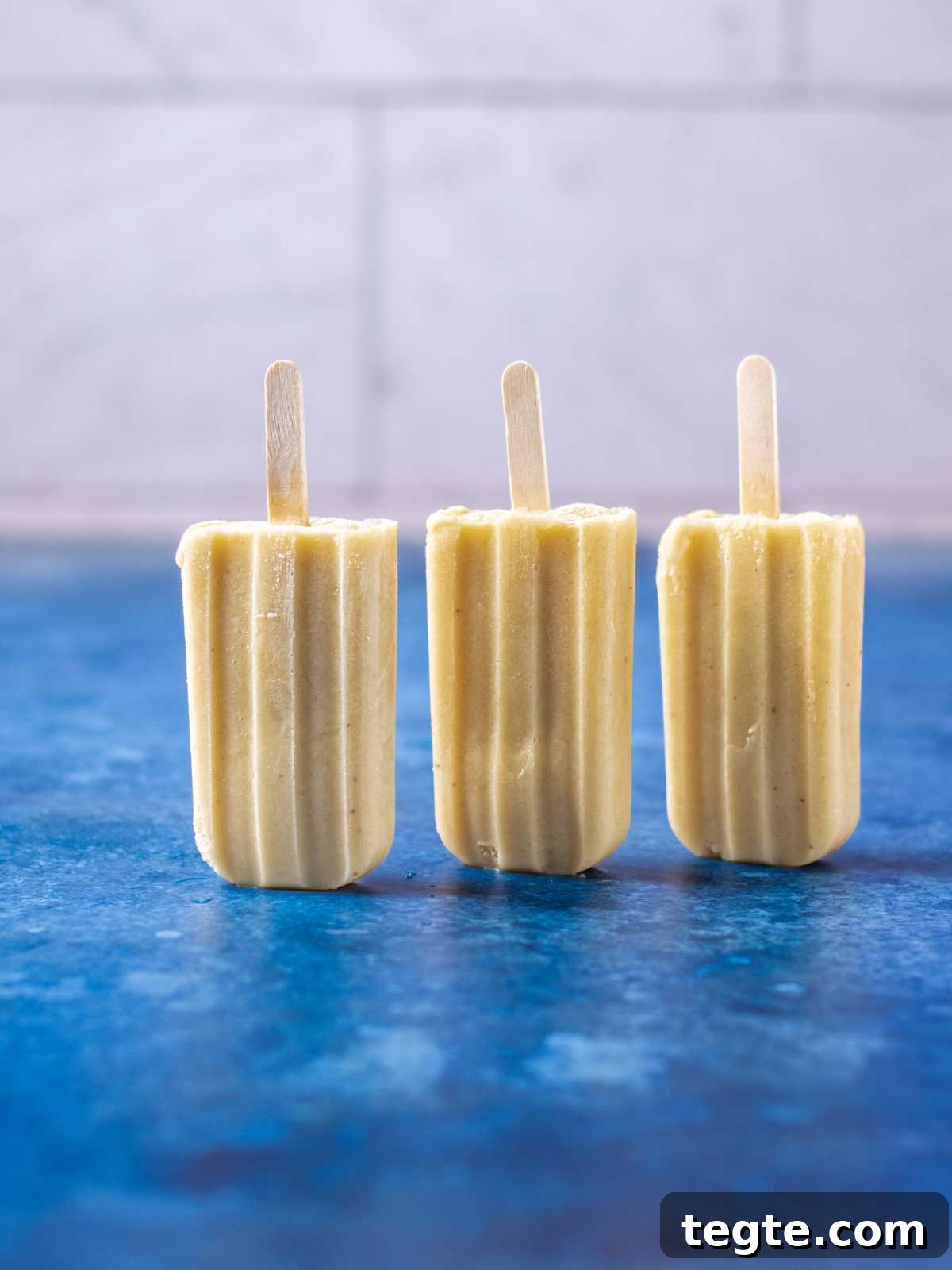 Creamy Homemade Banana Popsicles Recipe for Cooling Summer Treats 7 Stacked creamy pops on a flat surface.