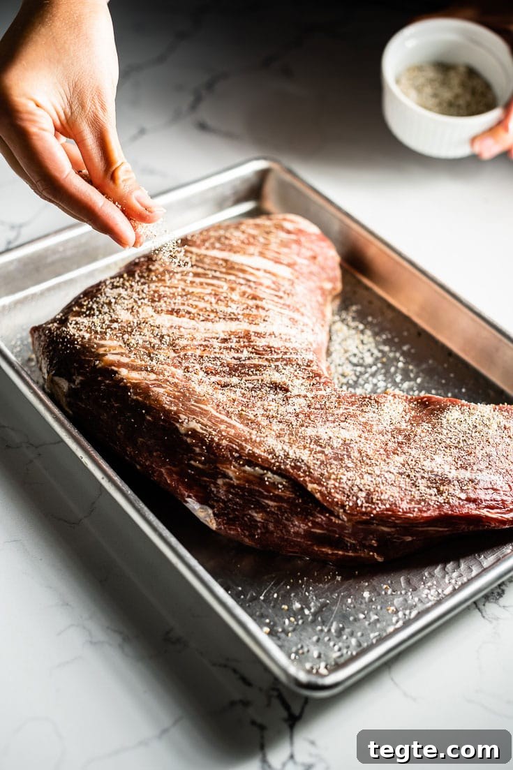 Smoked Tri-Tip Roast: Flavorful Low-and-Slow BBQ Recipe 2 applying seasoning to tri tip