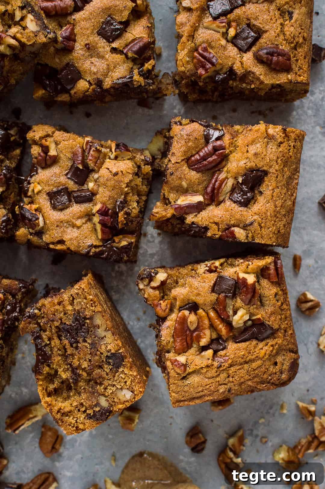 Squares of egg and dairy free peanut butter chocolate chip pecan bars.
