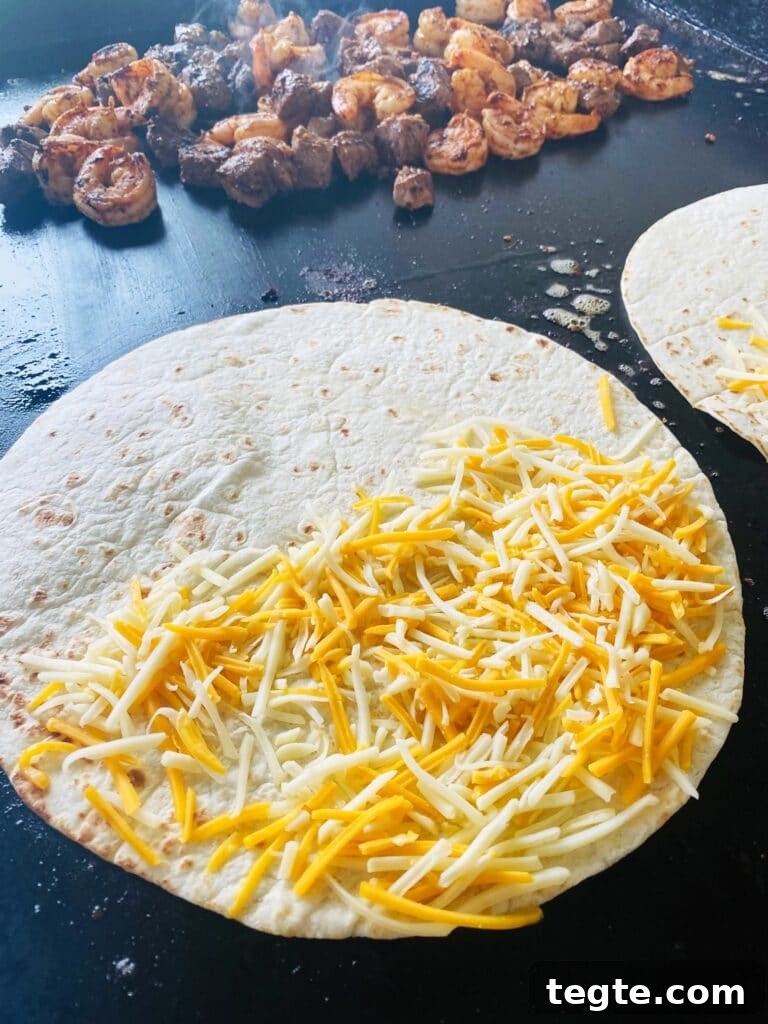 Blackstone Surf-and-Turf Quesadillas: Steak & Shrimp Grilled on a Flat Top 8 adding cheese to tortilla