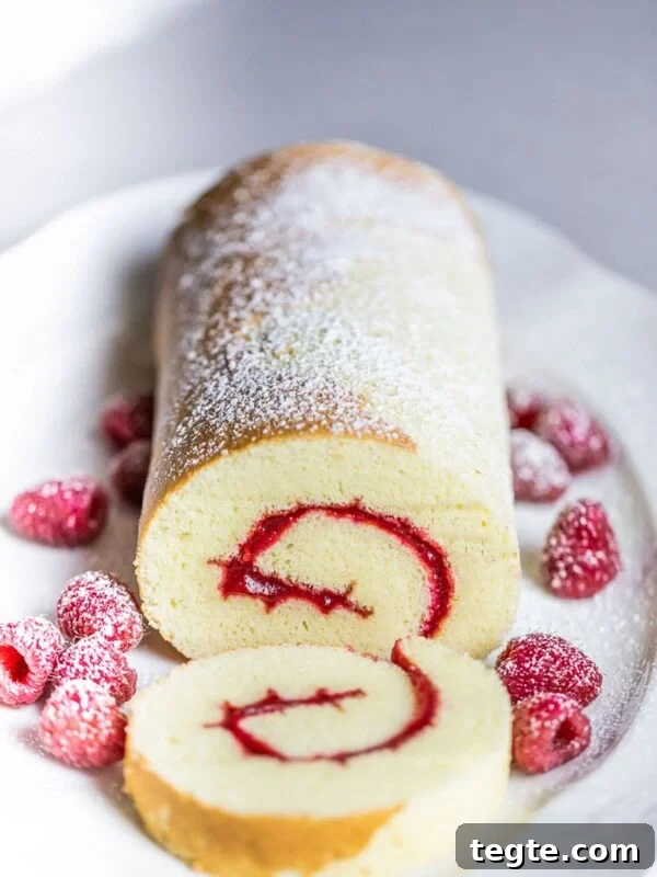 Authentic Japanese Strawberry Shortcake Recipe — Fluffy, Light Slice 14 swiss roll cake with raspberries on white plate