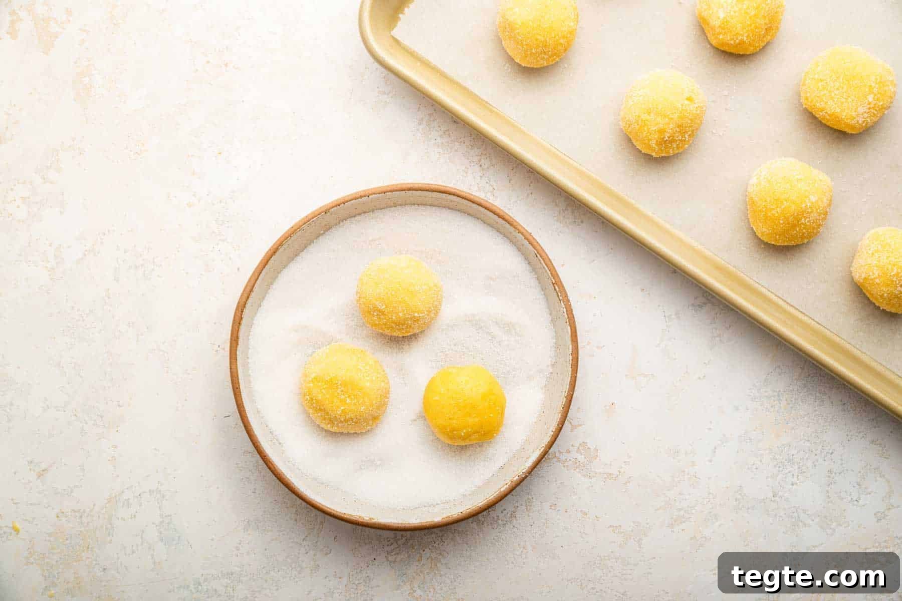 Crème Brûlée Cookies Recipe: Caramelized Sugar-Topped Cookie Treat 8 Three yellow dough balls rolling in sugar.