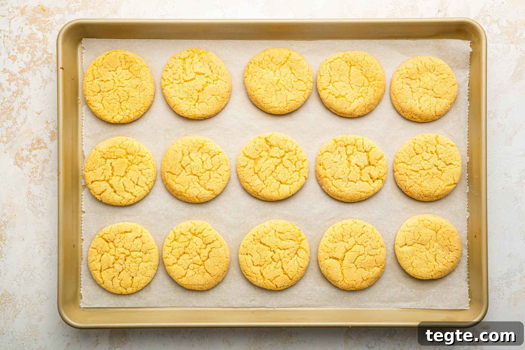 Crème Brûlée Cookies Recipe: Caramelized Sugar-Topped Cookie Treat 9 Horizontal image of freshly baked yellow cookies on a baking sheet.