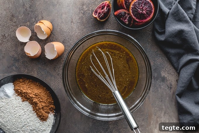 Dairy-Free Blood Orange Chocolate Cake Recipe 4 Wet ingredients being whisked together in a glass bowl.