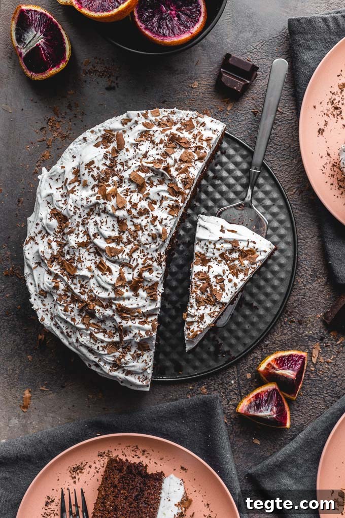 Dairy-Free Blood Orange Chocolate Cake Recipe 9 Overhead view of blood orange cake with frosting and chocolate shavings being served onto plates.
