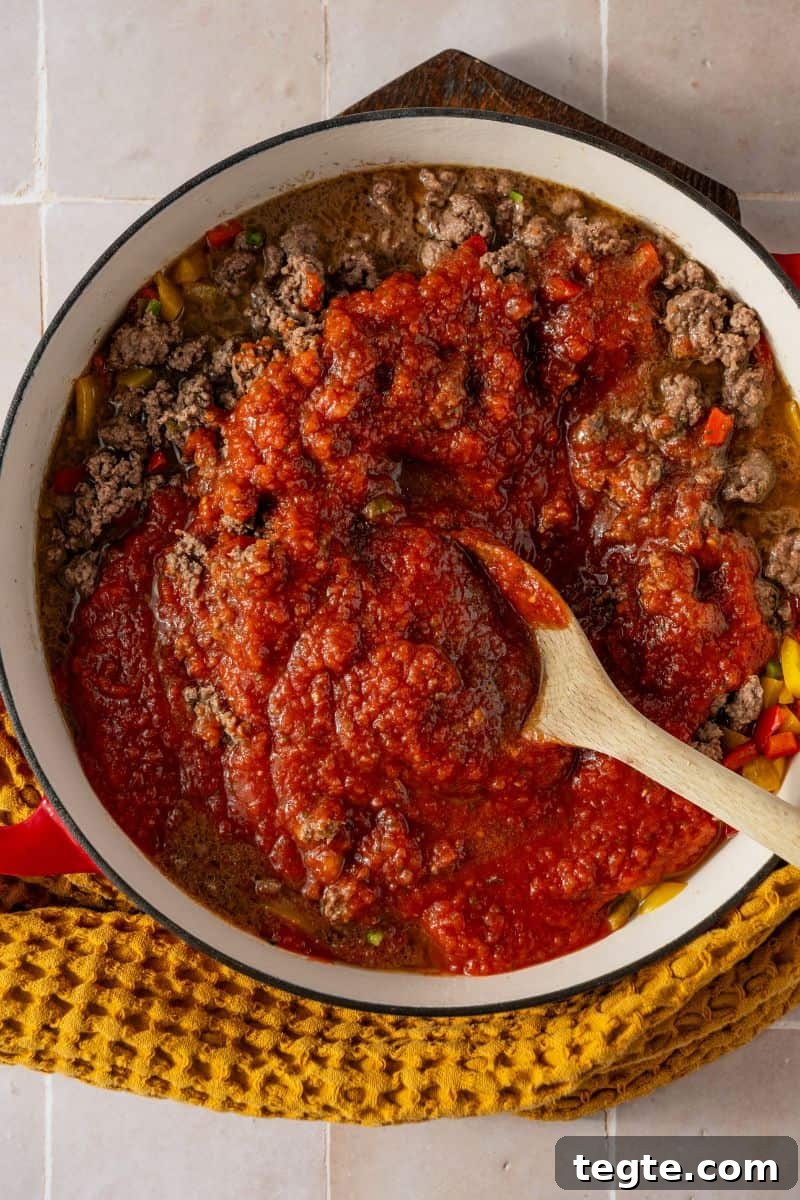 Lean Ground Beef Sloppy Joes with Tangy Tomato Sauce 8 A pan with cooked ground beef in it topped with tomato sauce.