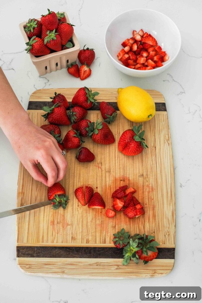 Homemade Small-Batch Strawberry Jam Recipe for Fresh Preserves 4 Strawberries being diced on a cutting board.