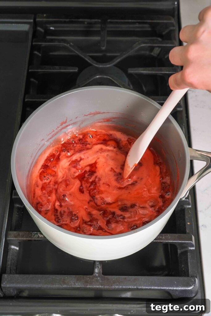 Homemade Small-Batch Strawberry Jam Recipe for Fresh Preserves 7 A spatula stirs strawberry jam in a pot.