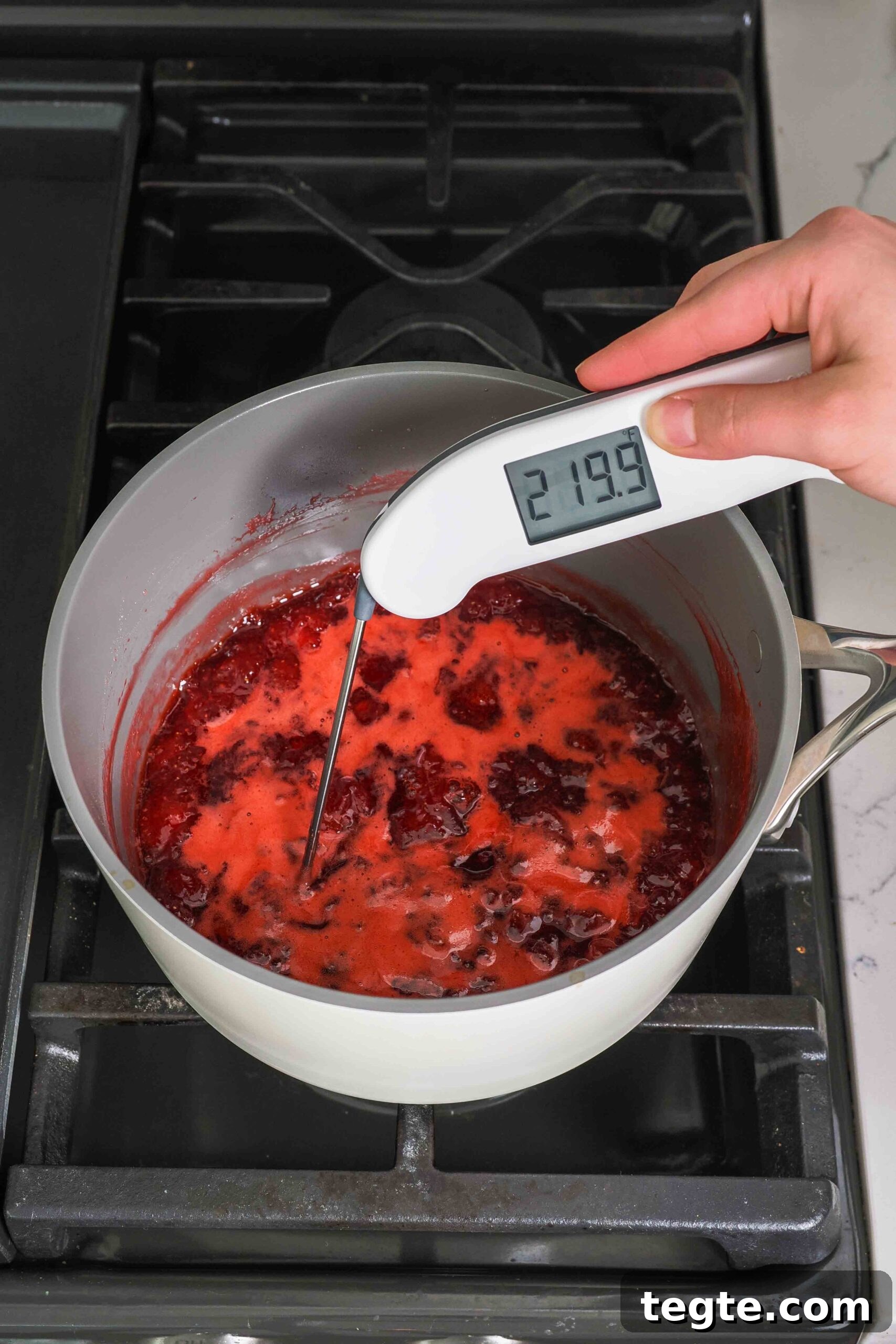 Homemade Small-Batch Strawberry Jam Recipe for Fresh Preserves 8 An instant-read thermometer reads 219.9°F over a boiling pot of strawberry jam.
