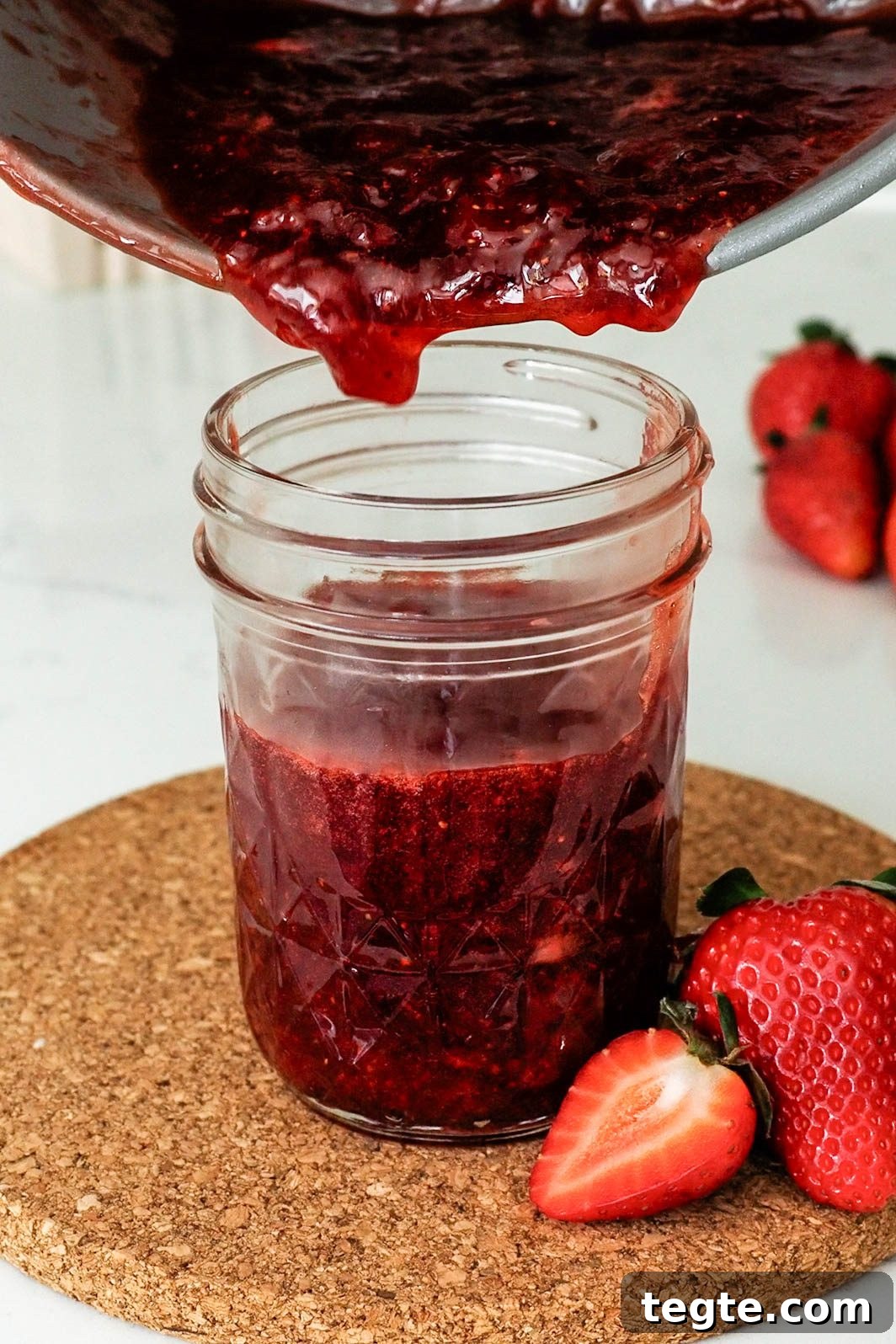 Homemade Small-Batch Strawberry Jam Recipe for Fresh Preserves 10 Strawberry jam is poured into a jelly jar.