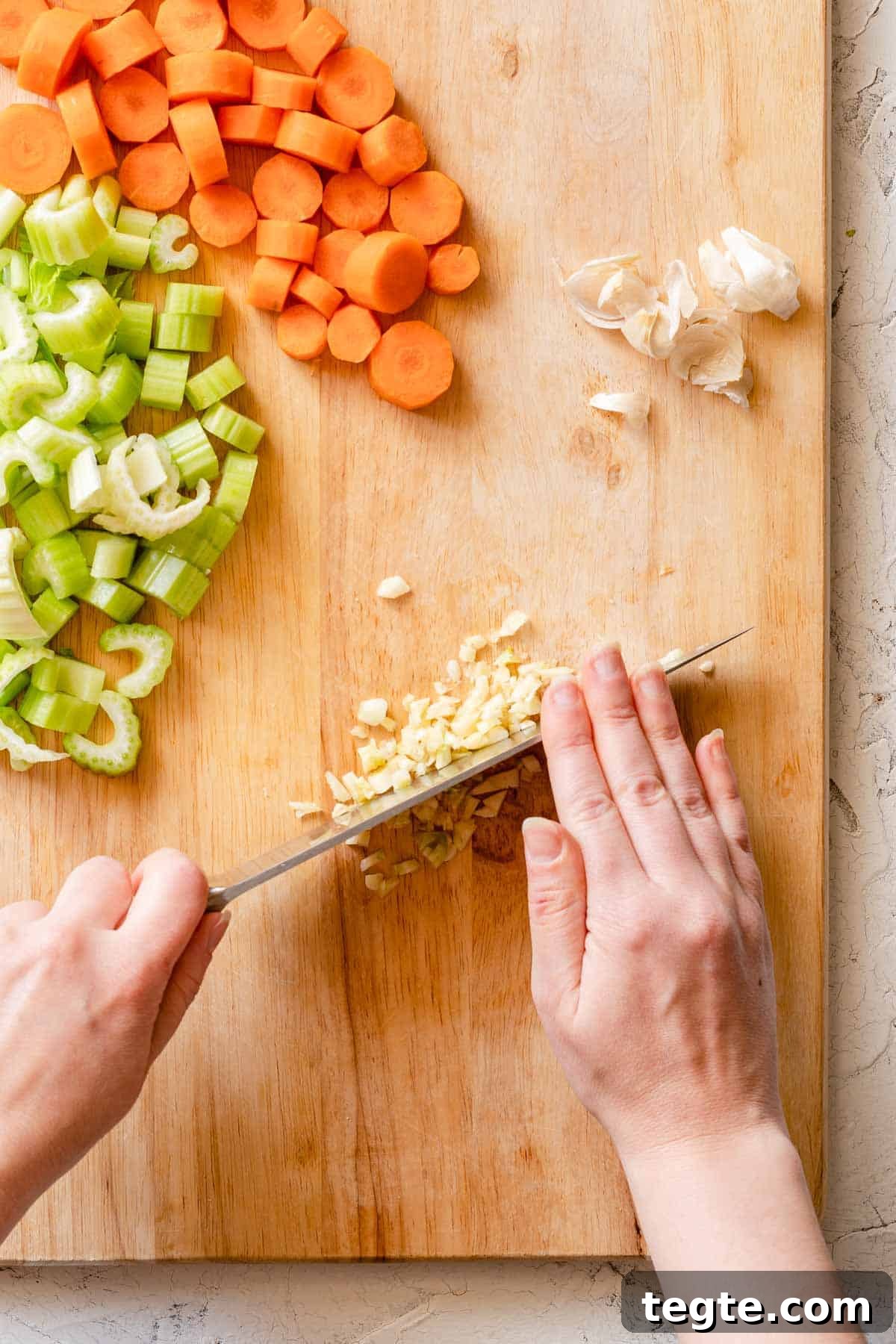 garlic being chopped on cutting board