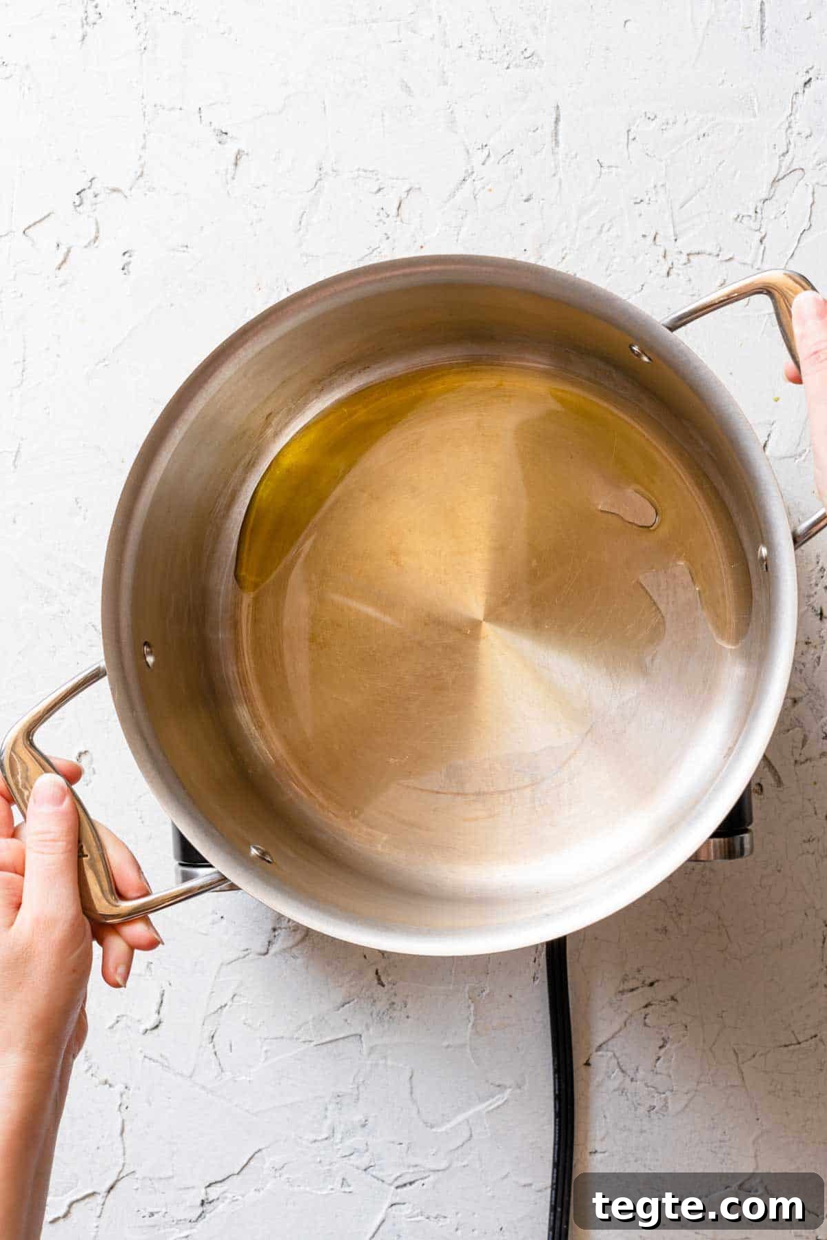 oil being swirled on bottom of soup pot