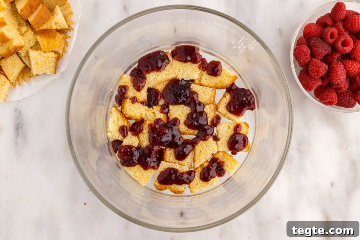 Decadent Raspberry Trifle Recipe with Fresh Cream and Cake 12 raspberry jam over pound cake in a trifle bowl