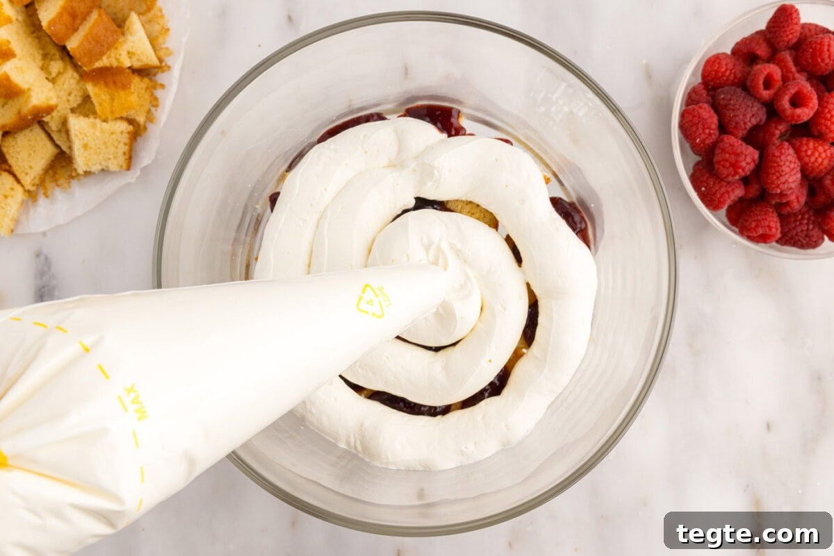 Decadent Raspberry Trifle Recipe with Fresh Cream and Cake 13 piping whipped cream cream cheese mixture over pound cake and jam