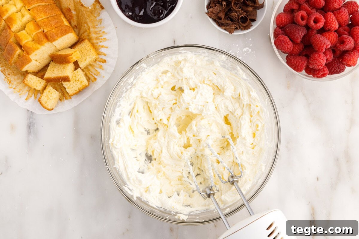 Decadent Raspberry Trifle Recipe with Fresh Cream and Cake 6 cream cheese mixture in a bowl with a mixer