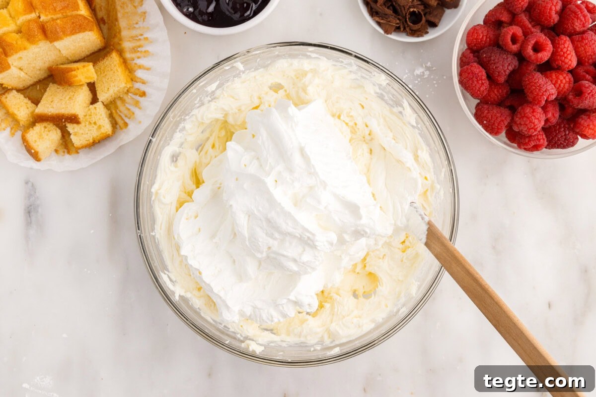 Decadent Raspberry Trifle Recipe with Fresh Cream and Cake 9 folding whipped cream into cream cheese mixture