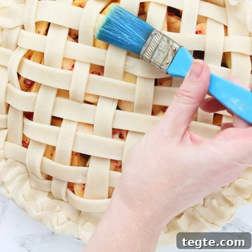 brushing egg wash on the lattice pie crust