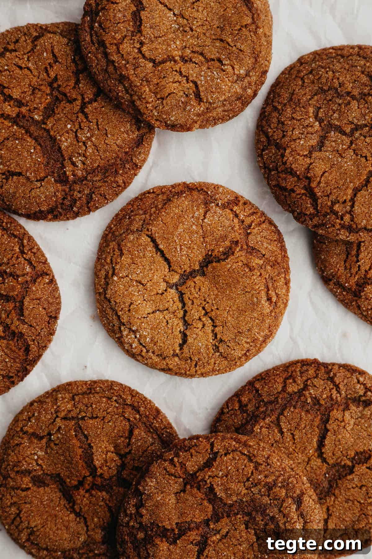 Ginger molasses crinkle cookies on parchment paper.