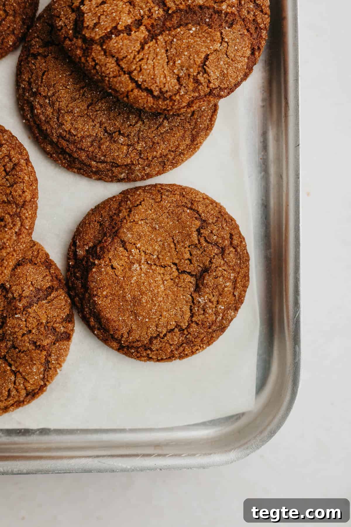 A baking sheet with molasses cookies on it.