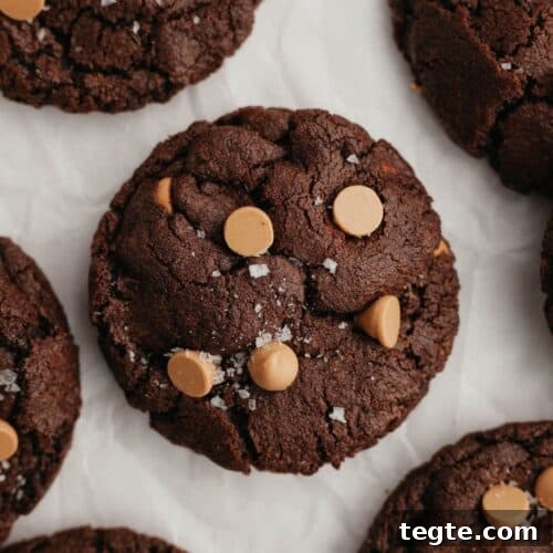 A close up of a chocolate caramel cookie on parchment paper.
