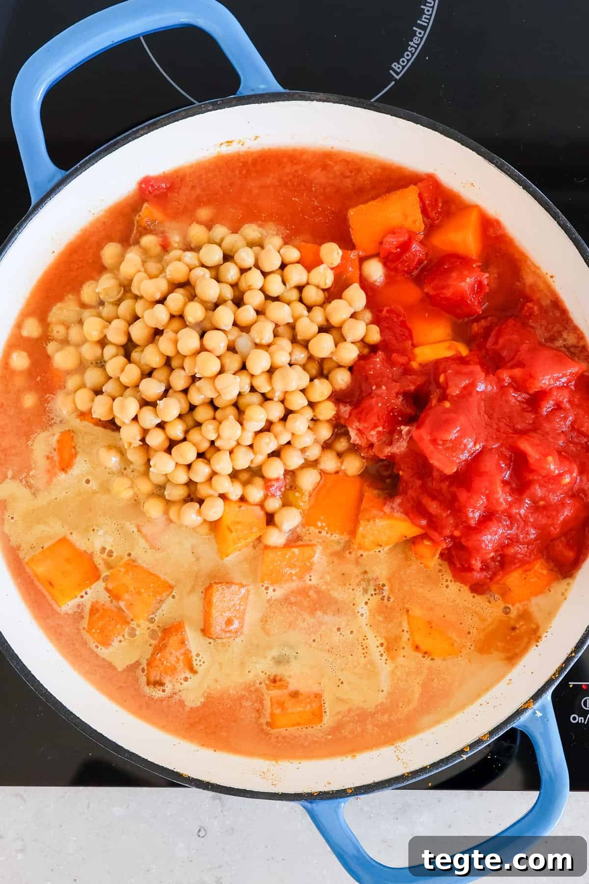 Butternut Squash and Chickpea Curry Recipe for Cozy Dinners 7 Tomatoes, chickpeas and peanut butter added to the pot.