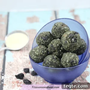 Energizing Spirulina Protein Balls (Gluten-Free) 12 Superfood energy balls in two glass blue bowls stacked with collagen powder behind them and dried blueberries around them