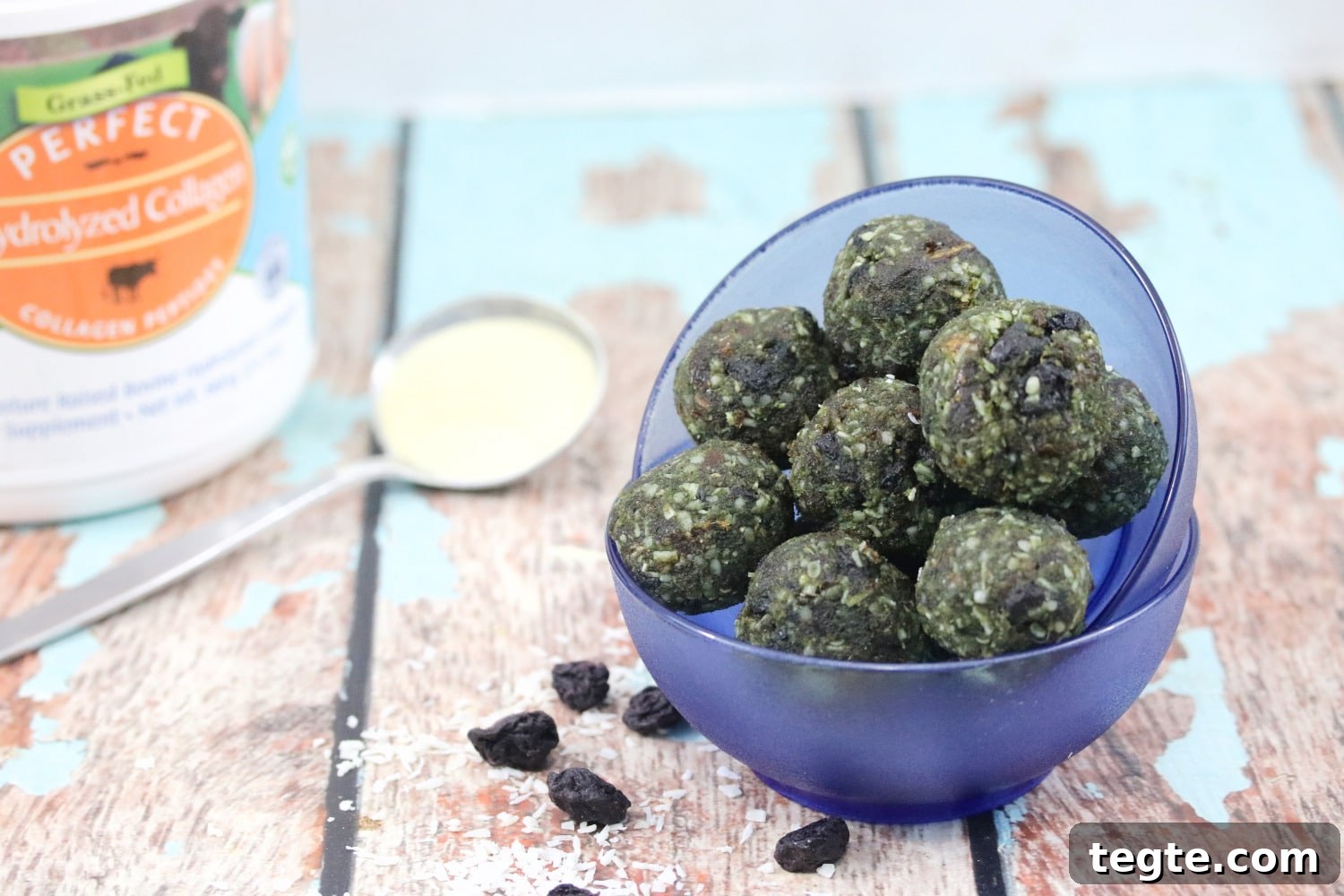 Energizing Spirulina Protein Balls (Gluten-Free) 13 Spirulina energy balls in a blue bowl with collagen powder and a tub behind them.
