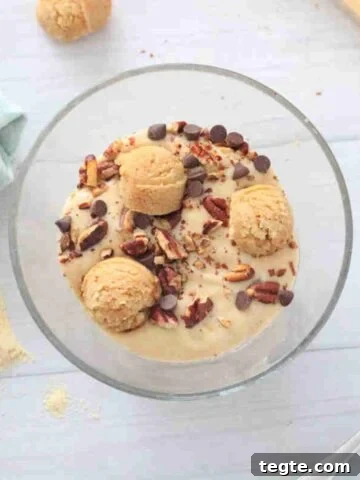 A bowl of protein cookie dough smoothie topped with cookie dough balls.