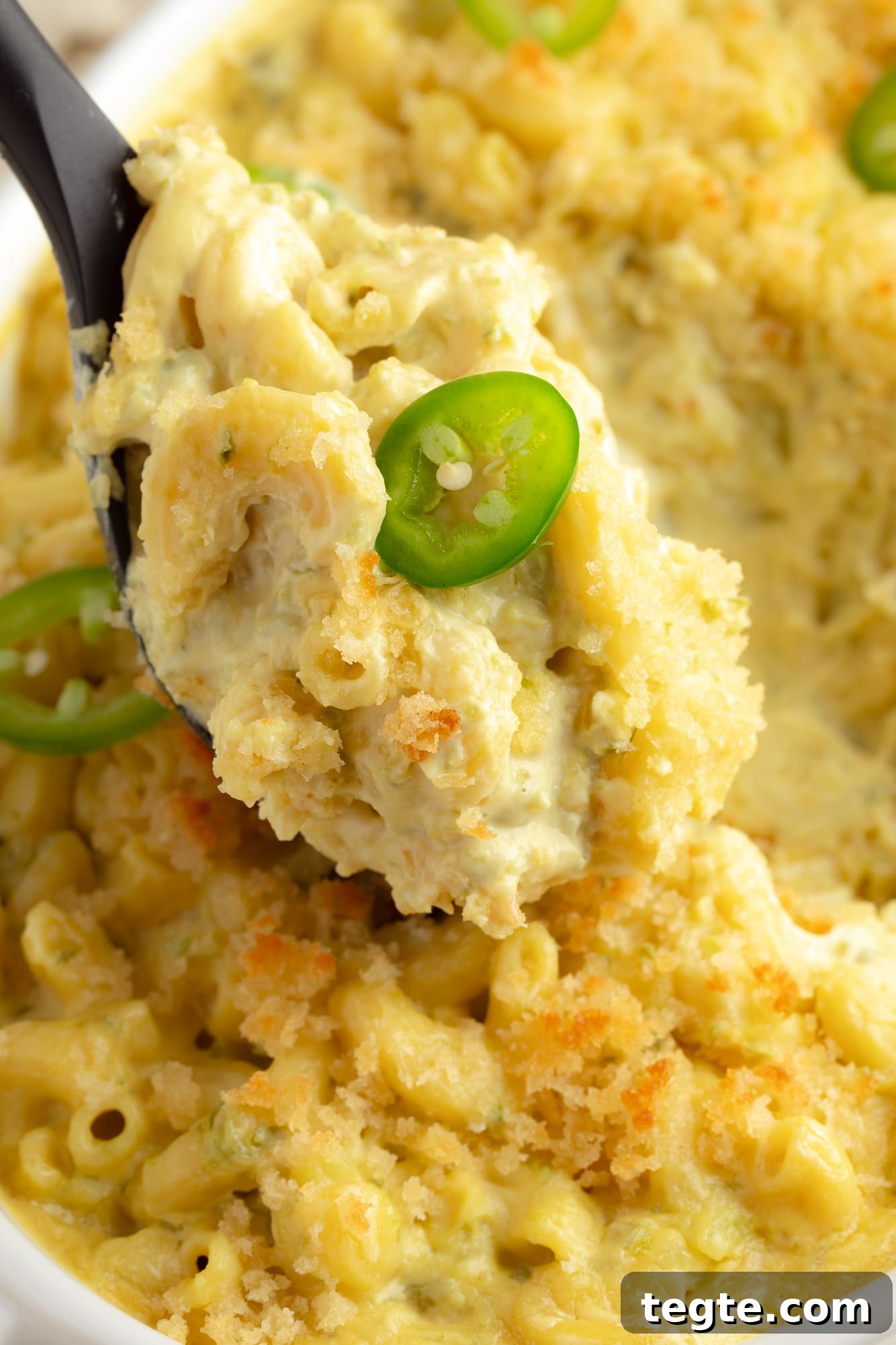 Creamy Vegan Jalapeño Mac and Cheese Recipe 3 close up on a black spoon holding a scoop of Vegan Jalapeño Mac and Cheese.
