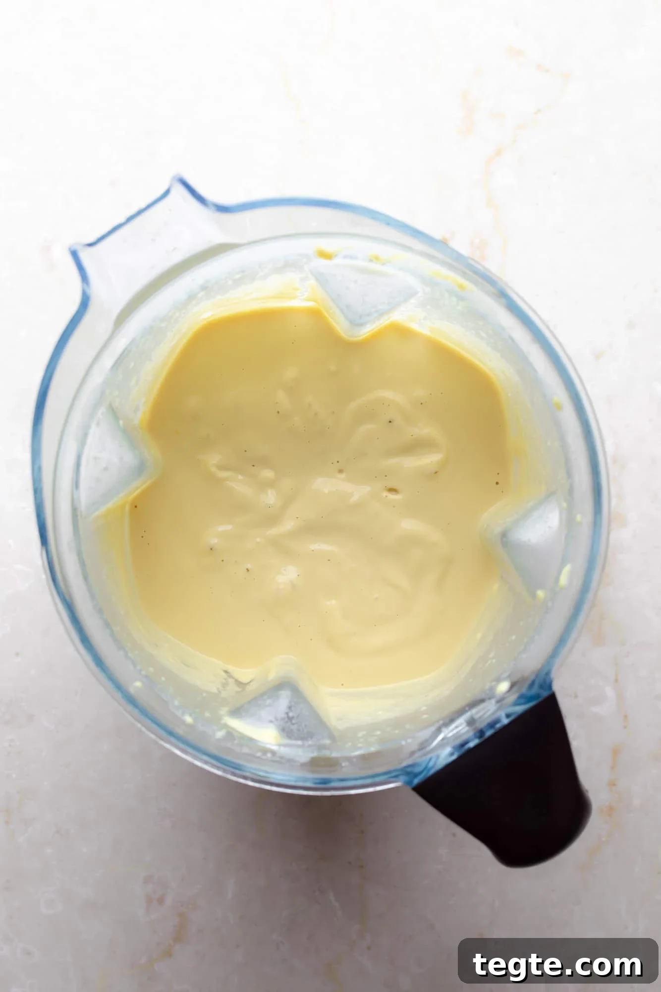 Creamy Vegan Jalapeño Mac and Cheese Recipe 4 overhead view of a white cashew cheese sauce in a blender.