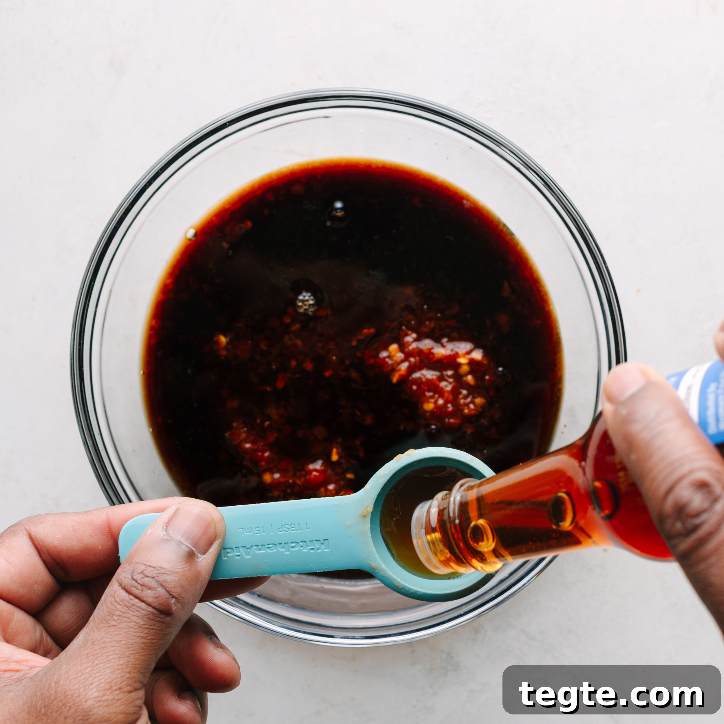 Asian Chili Garlic Chicken Wings Recipe 10 Asian wing sauce with sesame oil being added.
