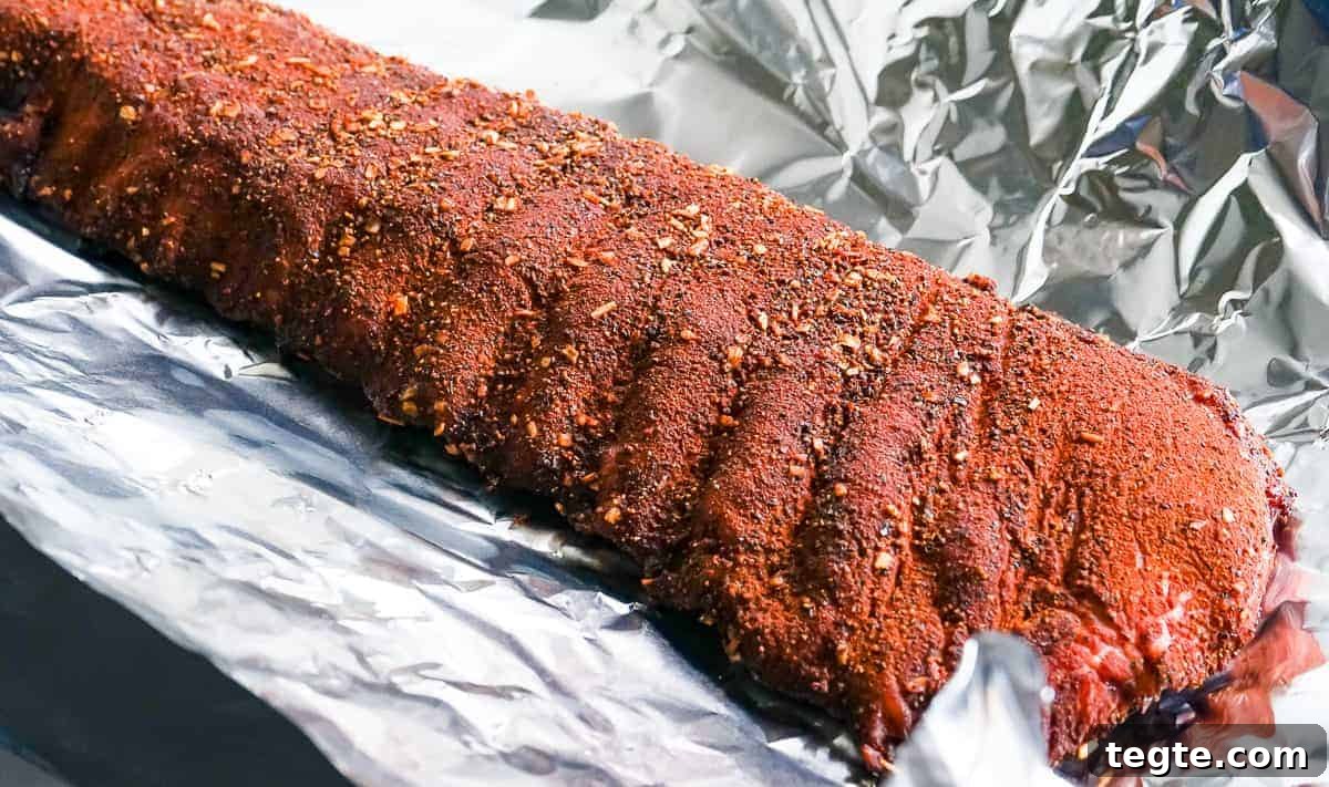 Baby back ribs being wrapped in foil
